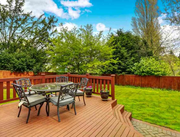 Large deck with dining space overlooking spacious well kept back yard.